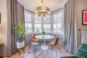 a dining room with a table and chairs in front of a window at No1 Apartments St Andrews - South Street in St Andrews