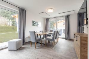 a dining room with a table and chairs at Englmar Chalets by ALPS RESORTS in Sankt Englmar