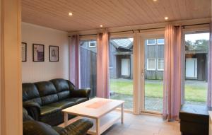 a living room with a leather couch and a table at Stunning Home In Søgne in Søgne