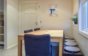 a dining room with a wooden table and blue chairs at Stunning Home In Søgne in Søgne
