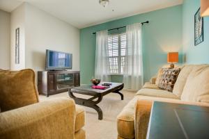 een woonkamer met een bank en een tv bij Top-Floor Luxurious LAKEVIEW Condo in Orlando
