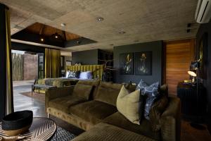 una sala de estar con un sofá y una cama en mFulaWozi Wilderness Biyela Lodge, en Sangoyana