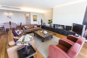 a living room with couches and a flat screen tv at Estoril Queens Apartment by CadenzaLux in Estoril