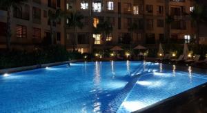 a large swimming pool in front of a building at night at Cozy apartment 2BR - Masteri Thao Dien , D2 in Ho Chi Minh City