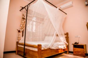 a bedroom with a bed with a mosquito net at Randa Cottages Moshi in Kirua