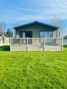 a house with a white fence in front of a yard at Fox Lodge with Hot Tub in York