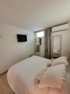 Un dormitorio con una gran cama blanca y una ventana en Playa Canadell MAR P primera línea de mar con terraza, en Calella de Palafrugell