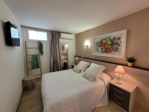 a bedroom with a white bed and a window at Playa Canadell MAR P primera línea de mar con terraza - WeHost Costa Brava in Calella de Palafrugell