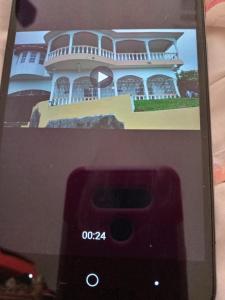 telefon komórkowy ze zdjęciem domu w obiekcie Royal Villa 360 w mieście Port Antonio