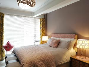 een slaapkamer met een bed met 2 lampen en een raam bij Award Winning 2023 luxury Holiday Rental Apartment Stratford London in Londen