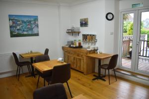 a restaurant with wooden tables and chairs in a room at Acorn Lodge in Torquay