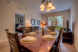Cozy Condo w FREE Vista Cay Resort Access في أورلاندو: غرفة طعام وغرفة معيشة مع طاولة وكراسي