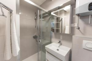 a white bathroom with a sink and a shower at Apartments M&A in Makarska +127 photos