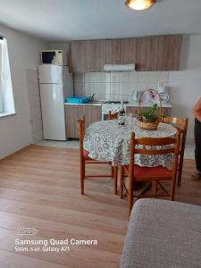 cocina con mesa y sillas y cocina con nevera en Apartments Ljubica, en Polje