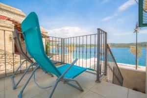a pair of chairs on a balcony with a view of the water at Mall Primosten in Primošten