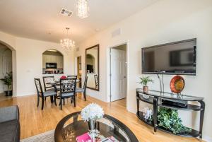a living room with a large television and a table at Luxurious Condo w Modern Design, near Disney in Orlando