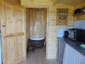 a kitchen with a large tub in a wooden cabin at Secret & Secluded Sedlescombe in Battle