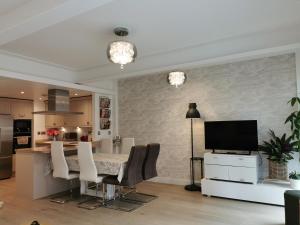 een keuken en een woonkamer met een tafel en een televisie bij Award Winning 2023 luxury Holiday Rental Apartment Stratford London in Londen