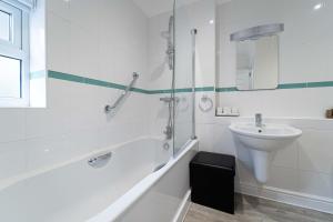 a white bathroom with a sink and a shower at The Barn in St Ives +10 photos