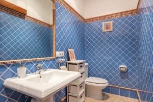a blue tiled bathroom with a sink and a toilet at Ca Na Bel 4 bedroom house, Ciutadella in Ciutadella +19 photos