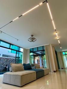 ein Schlafzimmer mit einem Bett in einem Zimmer mit Fenstern in der Unterkunft Ikiru 18 Private Saltwater Pool Villa, 3 Ensuite BR, Outdoor BBQ, 5 mins to Beach in Pantai Cenang