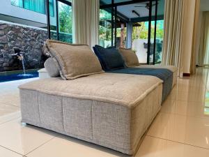 a large couch sitting in a living room at Ikiru 18 Private Saltwater Pool Villa, 3 Ensuite BR, Outdoor BBQ, 5 mins to Beach in Pantai Cenang
