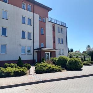 a large building with bushes in front of it at Apartament 35 in Olsztynek