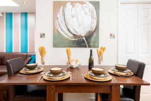 - une table à manger avec des assiettes et une bouteille de vin dans l'établissement BOURNECOAST: LOVELY ANNEX WITH PATIO NR BEACH-5286, à Bournemouth