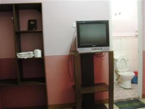 a tv on a stand in a room with a toilet at GV Hotel - Cagayan de Oro in Cagayan de Oro