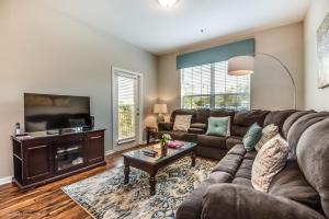 ein Wohnzimmer mit einem Sofa und einem TV in der Unterkunft Stylish Vista Cay Condo, near Orlando attractions in Orlando
