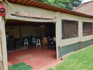 a covered patio with a sign that reads the barrel and swing at The Lazy Grape Guest Lodge & Spa in Benoni