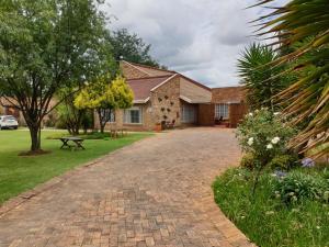 a brick driveway in front of a house at The Lazy Grape Guest Lodge & Spa in Benoni