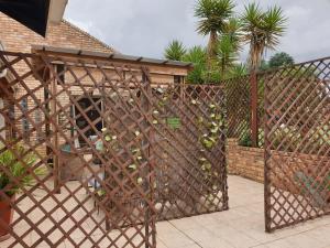 a fence with a bunch of wine bottles on it at The Lazy Grape Guest Lodge & Spa in Benoni