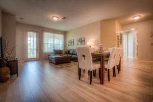 a living room with a table and chairs and a couch at Beautiful LAKEVIEW Deluxe Condo Near Theme Parks in Orlando