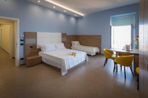 a bedroom with two beds and a table and a desk at Al Duomo B&B in Amantea