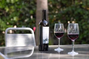 a bottle of wine sitting on a table with two wine glasses at Nura Houses Condor in Playa de Palma