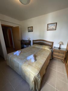 a bedroom with a large bed with towels on it at Apartamentos Santa Teresinha in Alvor