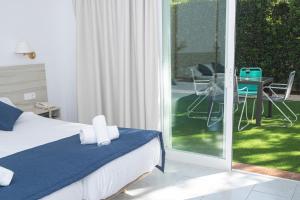 a bedroom with a bed and a sliding glass door at NURA Apartments - Condor in Palma de Mallorca