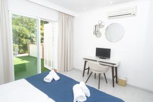 Camera bianca con scrivania e computer. di NURA Apartments - Condor a Palma de Mallorca