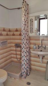 a bathroom with a tub and a sink and a toilet at Hellmann Apartments in Afionas