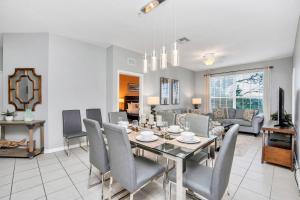 uma sala de jantar e sala de estar com mesa e cadeiras em Updated LAKEVIEW Condo, Minutes from Disney em Orlando