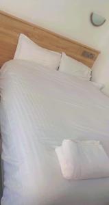 - un lit blanc avec des draps et des oreillers blancs dans l'établissement Entire Two Double Bedrooms Flat N4, à Great Yarmouth