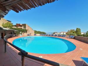una gran piscina con sillas en un patio en Le Terrazze Di Baja Sardinia, en Baja Sardinia