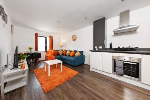 a living room with a blue couch and a kitchen at 40 Percent OFF - Long Stays - City Centre - Close to Bullring - Suitable for Business, Families, Relocations and Leisure - EastGate l Free WiFi I in Birmingham