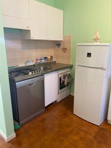 a kitchen with a stove and a sink and a refrigerator at A casa di Nonna Maria in Marcelli