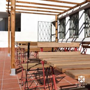 wiersz drewnianych stołów i ławek w budynku w obiekcie Batalhoz House w mieście Cartaxo
