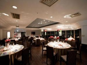 a dining room with tables and chairs with flowers on them at Sendai Hills Hotel in Sendai