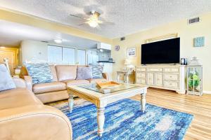 sala de estar con sofá y TV en Beach Palms 406, en Clearwater Beach