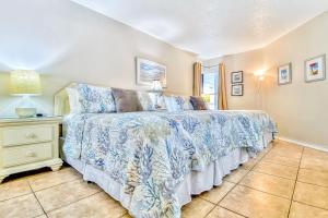 una camera con un letto con copriletto blu e bianco di Beach Palms 406 a Clearwater Beach Altre 18 foto