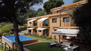 a building with a swimming pool in front of it at VILLA LA CALA with swimming pool & sea view, 10 min walk from the sea in Blanes